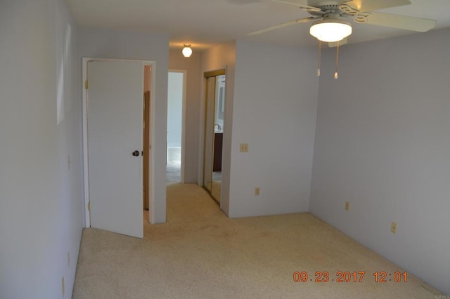 spare room featuring light carpet and ceiling fan