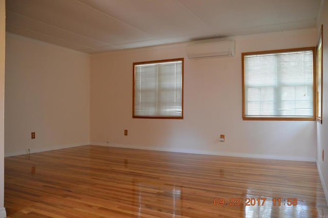 spare room with light hardwood / wood-style floors and a wall mounted air conditioner