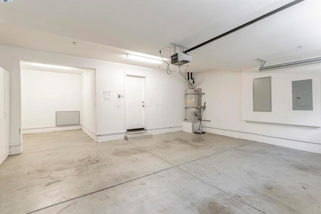 garage featuring a garage door opener, electric panel, and strapped water heater