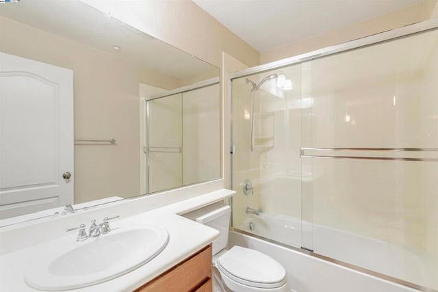 full bathroom with toilet, bath / shower combo with glass door, and vanity