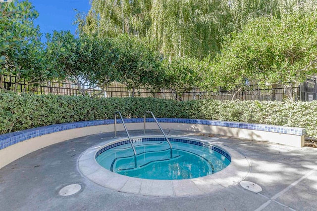 view of swimming pool featuring a patio and a hot tub