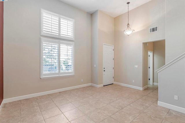 foyer with a towering ceiling and light tile patterned floors