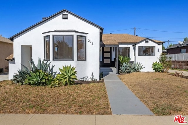 bungalow-style home with a front lawn