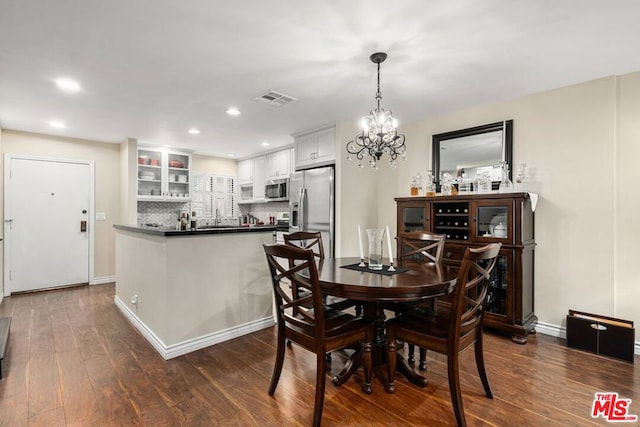 dining room with dark wood-type flooring and a notable chandelier