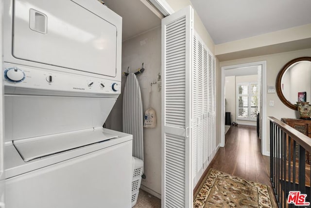 washroom featuring dark hardwood / wood-style floors and stacked washer and clothes dryer