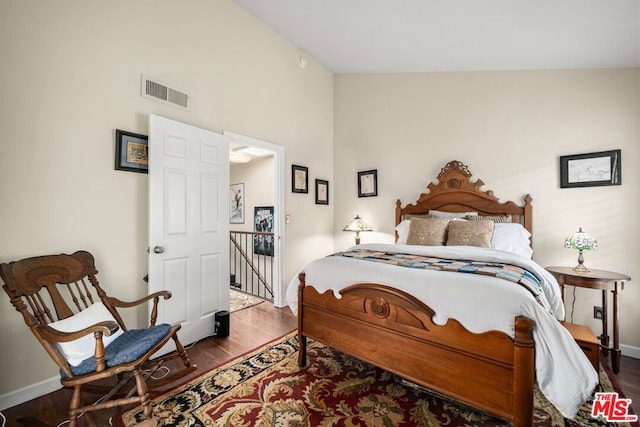 bedroom featuring dark hardwood / wood-style floors and high vaulted ceiling