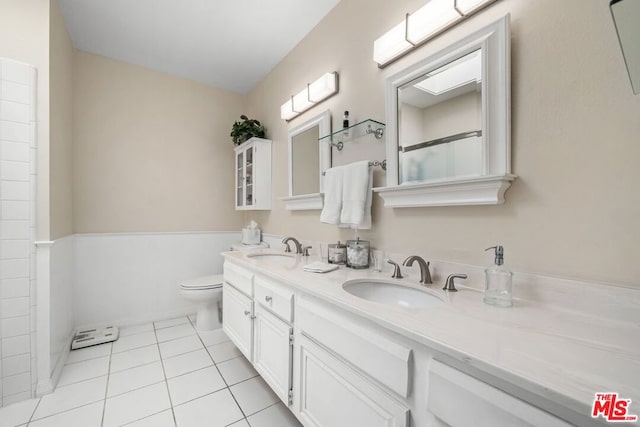 bathroom with toilet, vanity, and tile patterned floors