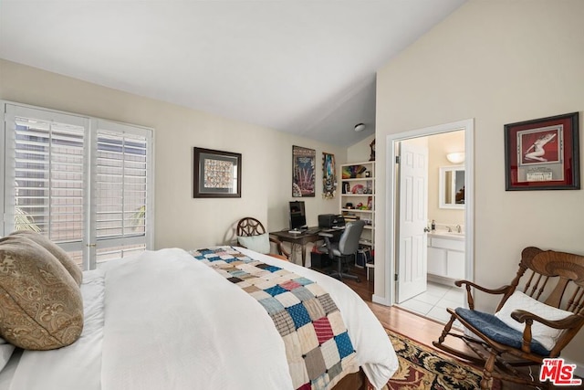 bedroom featuring connected bathroom, light hardwood / wood-style floors, and vaulted ceiling