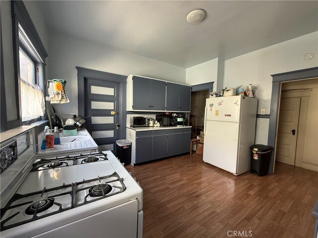 kitchen featuring dark hardwood / wood-style floors and white appliances