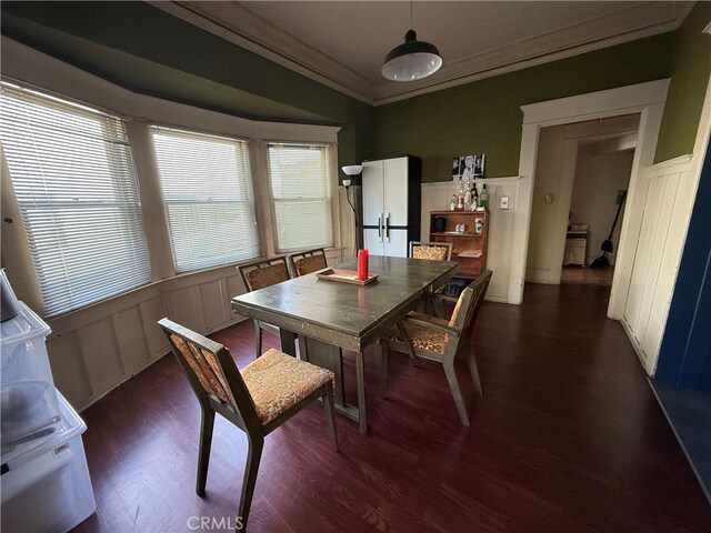 dining area featuring dark wood-type flooring and ornamental molding