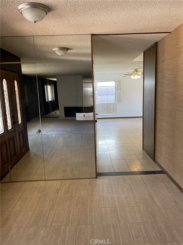 37800 Rudall Ave, Palmdale, CA 93550 - entrance foyer featuring a textured ceiling, ceiling fan, and a fireplace
