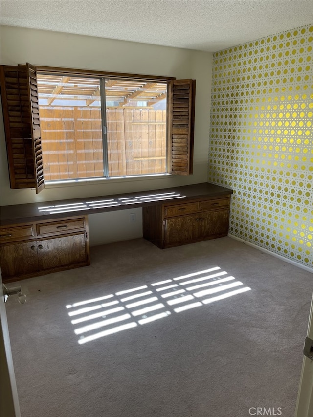 37800 Rudall Ave, Palmdale, CA 93550 - empty room featuring carpet floors, a textured ceiling, wallpapered walls, and an office area