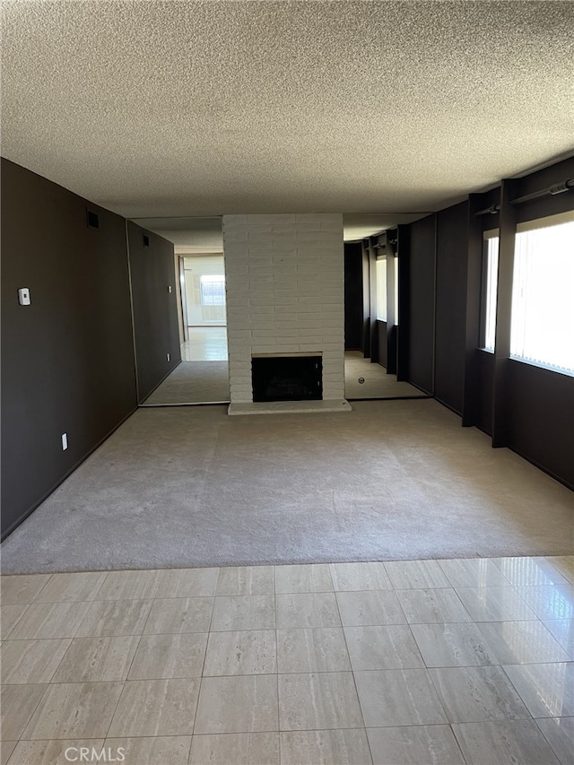 37800 Rudall Ave, Palmdale, CA 93550 - unfurnished living room featuring light carpet, a textured ceiling, a brick fireplace, and plenty of natural light