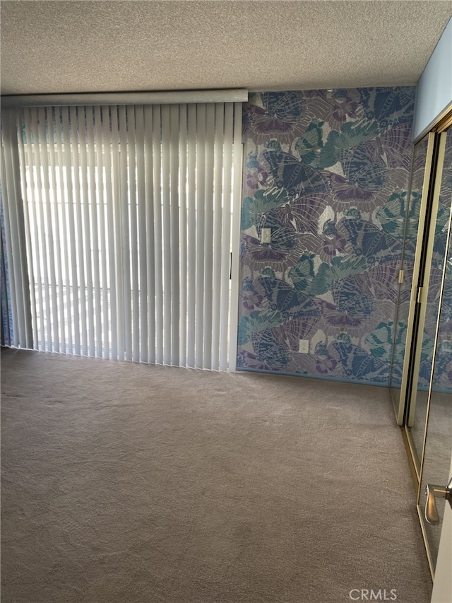 37800 Rudall Ave, Palmdale, CA 93550 - empty room with carpet floors, a textured ceiling, and wallpapered walls