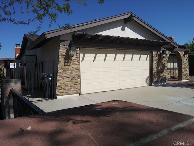 37800 Rudall Ave, Palmdale, CA 93550 - view of home's exterior featuring stone siding, a garage, concrete driveway, stucco siding, and a gate