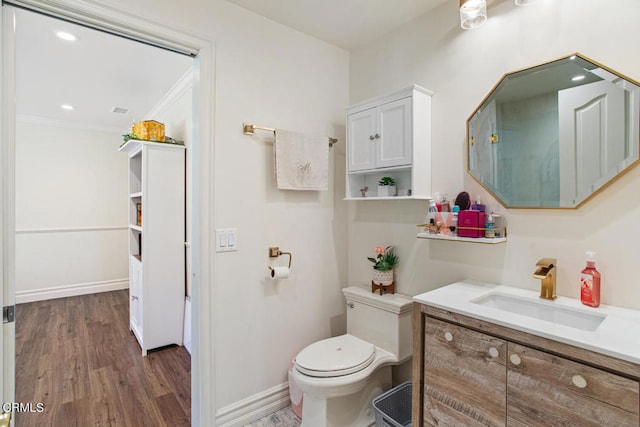 bathroom featuring vanity, crown molding, wood-type flooring, and toilet