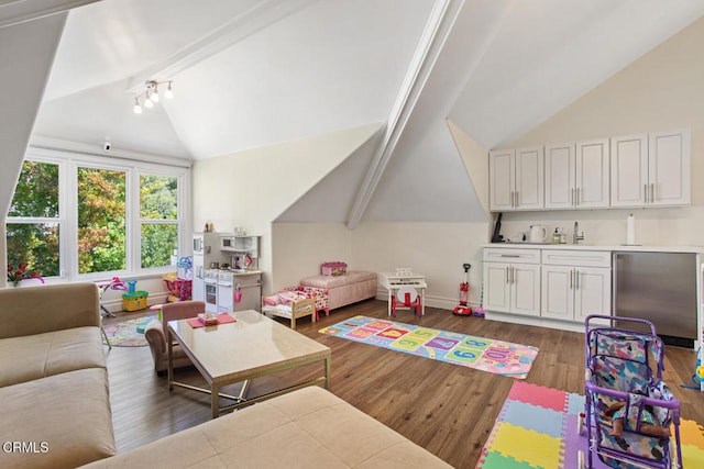 recreation room featuring vaulted ceiling with beams, dark hardwood / wood-style floors, and track lighting