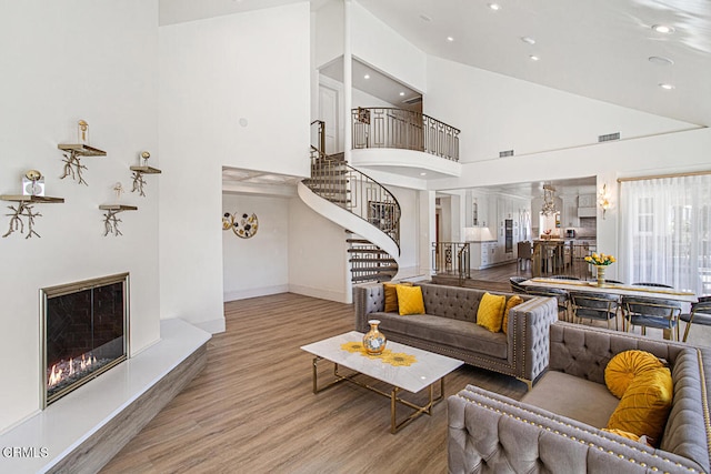 living room with light hardwood / wood-style flooring and high vaulted ceiling