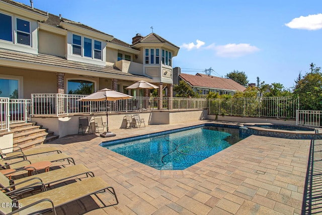 view of pool with a patio and an in ground hot tub