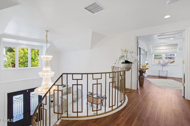 corridor with an inviting chandelier and hardwood / wood-style flooring