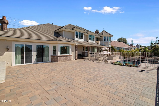 back of house featuring a patio and a fenced in pool