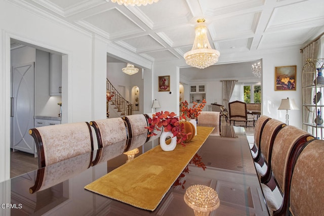 dining area with beam ceiling, coffered ceiling, ornamental molding, and an inviting chandelier