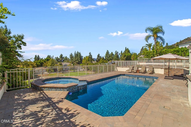 view of swimming pool featuring a patio and an in ground hot tub