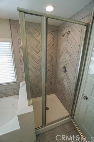 bathroom featuring shower with separate bathtub