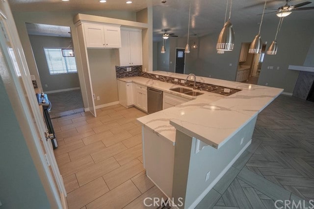 kitchen featuring white cabinetry, light stone countertops, sink, and kitchen peninsula