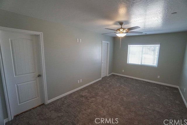 carpeted spare room with ceiling fan and a textured ceiling