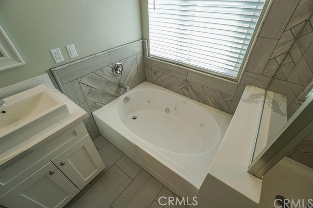 bathroom with vanity, tile patterned flooring, and a washtub