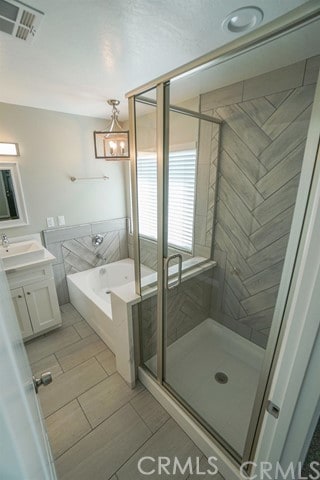 bathroom featuring vanity and independent shower and bath