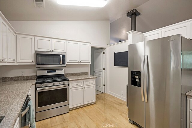 14331 Troy Way, Magalia, CA 95954 - kitchen with lofted ceiling, light wood finished floors, visible vents, white cabinets, and appliances with stainless steel finishes