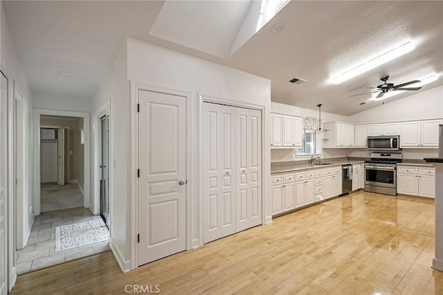 14331 Troy Way, Magalia, CA 95954 - kitchen with lofted ceiling, visible vents, a sink, stainless steel appliances, and white cabinets