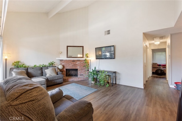 living room featuring beamed ceiling, high vaulted ceiling, dark wood-type flooring, and a fireplace