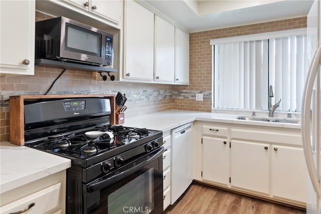 kitchen with white cabinetry, dishwasher, sink, and black range with gas cooktop