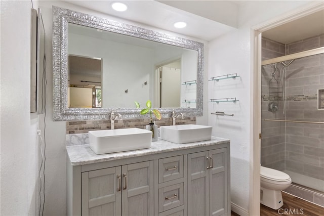 bathroom featuring vanity, hardwood / wood-style floors, toilet, and an enclosed shower