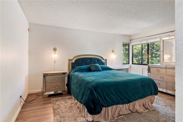 bedroom with hardwood / wood-style floors and a textured ceiling