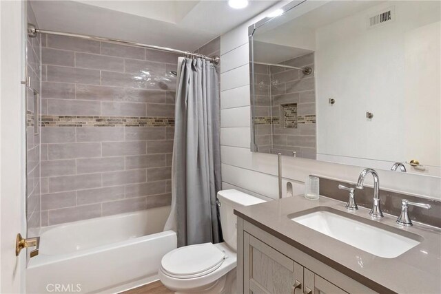 full bathroom with toilet, visible vents, shower / bath combination with curtain, and vanity