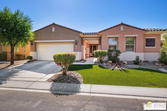 mediterranean / spanish-style house featuring a front yard and a garage