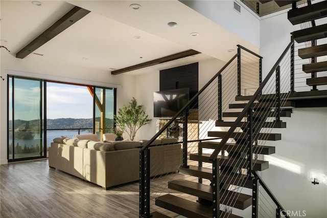 unfurnished living room with beamed ceiling and hardwood / wood-style flooring