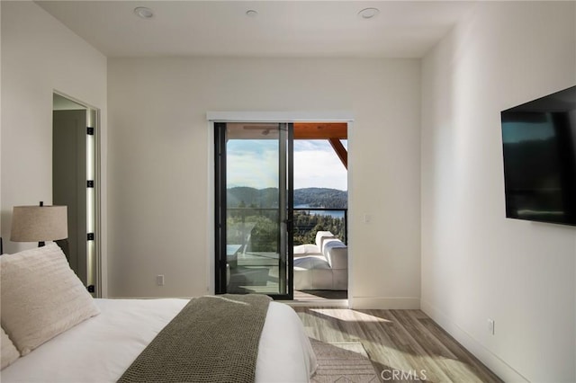 bedroom with access to outside and light hardwood / wood-style flooring