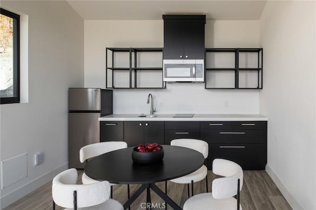 kitchen featuring wood-type flooring, stainless steel appliances, and sink