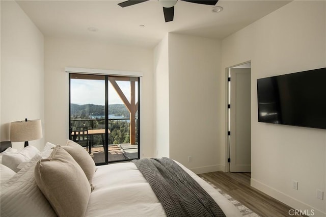 bedroom with access to exterior, hardwood / wood-style floors, and ceiling fan