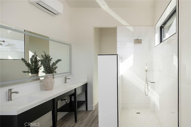 bathroom featuring tiled shower, vanity, a wall mounted air conditioner, and hardwood / wood-style flooring