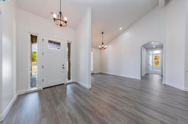 foyer with dark wood-type flooring and high vaulted ceiling