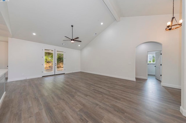 unfurnished living room featuring ceiling fan with notable chandelier, high vaulted ceiling, beamed ceiling, and dark hardwood / wood-style floors