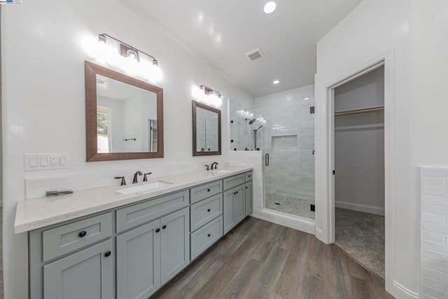 bathroom with vanity, hardwood / wood-style flooring, and walk in shower