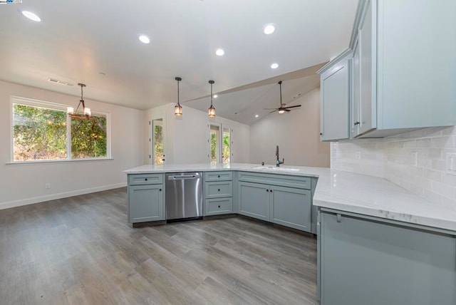 kitchen with kitchen peninsula, stainless steel dishwasher, and plenty of natural light