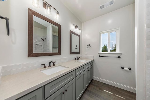 bathroom with vanity, decorative backsplash, walk in shower, and hardwood / wood-style floors